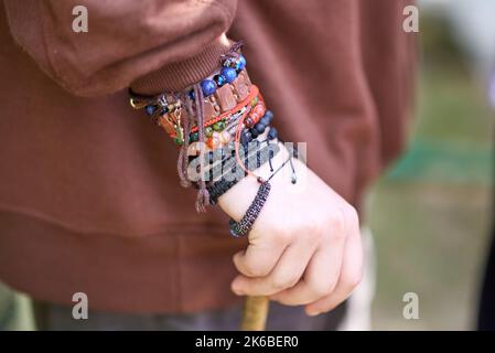 Eine Kollektion von mehrfarbigen Armbändern am Handgelenk einer Frau Stockfoto