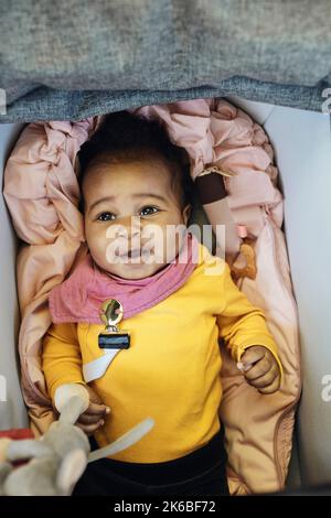 Direkt über der Ansicht des kleinen Mädchens, das im Kinderwagen liegt Stockfoto