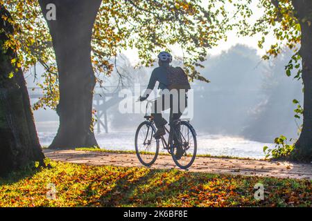 Preston, Lancashire. Wetter in Großbritannien; 13. Oktober 2022. Die Sonne geht über dem River Ribble auf, während die Anwohner in der Morgendämmerung am Riverside Walk, einem kalten nebligen Start in den Tag, leichte Übungen machen. Avenham Park Familienbereich, Rad- und Wanderwege im Nordwesten Englands. Kredit; MediaWorldImages/AlamyLiveNewsl Stockfoto