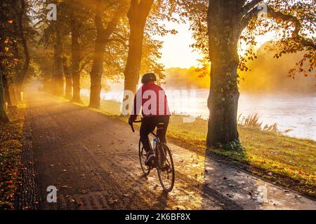 Preston, Lancashire. Wetter in Großbritannien; 13. Oktober 2022. Die Sonne geht über dem River Ribble auf, während die Anwohner in der Morgendämmerung am Riverside Walk, einem kalten nebligen Start in den Tag, leichte Übungen machen. Avenham Park Familienbereich, Rad- und Wanderwege im Nordwesten Englands. Kredit; MediaWorldImages/AlamyLiveNewsl Stockfoto