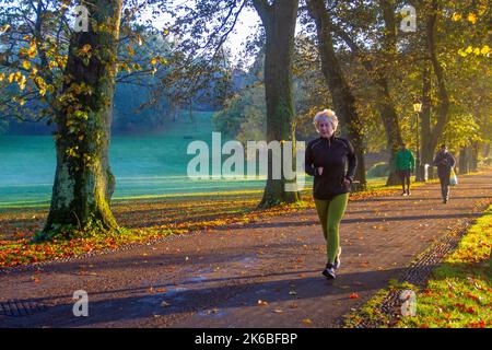 Preston, Lancashire. Wetter in Großbritannien; 13. Oktober 2022. Die Sonne geht über dem River Ribble auf, während die Anwohner in der Morgendämmerung am Riverside Walk, einem kalten nebligen Start in den Tag, leichte Übungen machen. Avenham Park Familienbereich, Rad- und Wanderwege im Nordwesten Englands. Kredit; MediaWorldImages/AlamyLiveNewsl Stockfoto