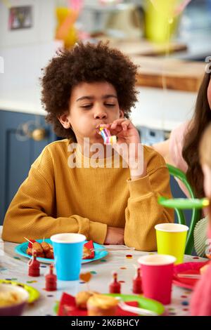 Junge Feiert Geburtstag Mit Party Gebläse Bei Party Mit Freunden Zu Hause Stockfoto