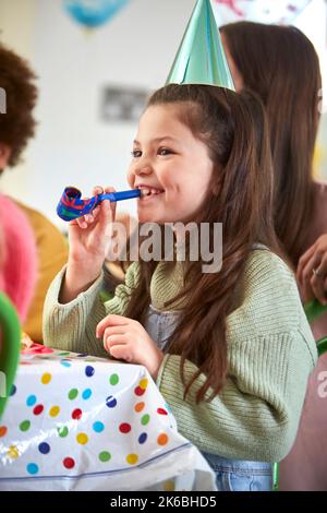 Mädchen Feiert Geburtstag Mit Party Blower Auf Party Mit Eltern Und Freunden Zu Hause Stockfoto