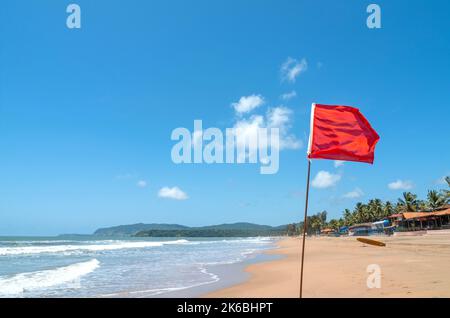 Rote Flagge als Warnschild am Strand vor Sturm bedeutet kein Schwimmen, an windigen sonnigen Tagen Stockfoto