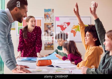 Gruppe Von Multikulturellen Schülern Mit Lehrern Im Klassenzimmer, Die Hand Auflegen, Um Die Frage Zu Beantworten Stockfoto