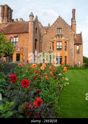 Chenies Manor und Garten umgeben von bunten Dahlien im Oktober. Stockfoto
