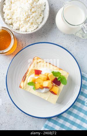 Kasserolle mit Quark, serviert mit Früchten und saurer Rahm. Süßes Frühstück, Käsepudding Stockfoto