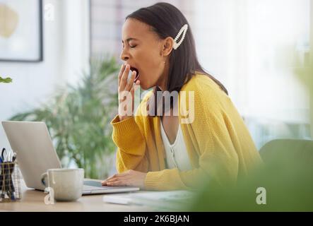 Es war ein langer Tag. Eine junge Geschäftsfrau gähnend, während sie in einem Büro arbeitete. Stockfoto