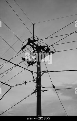 Monochromes Foto, ein mit unordentlichen Drähten gefüllter elektrischer Pol im Gebiet von Cikancung - Indonesien Stockfoto