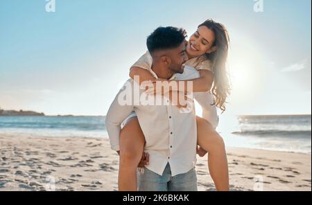 Sie haben mir ein dauerhaftes Lächeln ins Gesicht gegeben. Ein junges Paar, das am Strand Zeit zusammen verbringt. Stockfoto