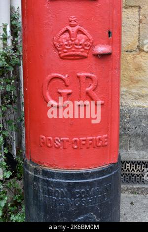 Nahaufnahme rot bemalter britischer Royal Mail Briefkasten draußen in einer Straße, mit Queens Krone und Initialen V R. Briefkasten ist der britische Monarch George VI Stockfoto