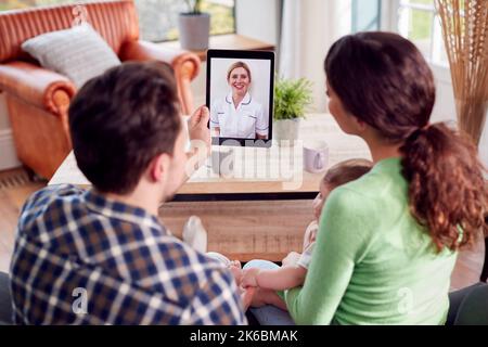 Transgender Familie Mit Baby Mit Virtuellem Postnatalen Videoanruf Mit Gesundheitsmitarbeitern Zu Hause Stockfoto