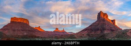 Sonnenuntergang auf den Sandsteinfelsen entlang der Ida Gulch in der Nähe von Moab, Utah. Von links: Kloster, Oberin, Pfarrhaus, Castle Rock & Parriott Mesa. Stockfoto