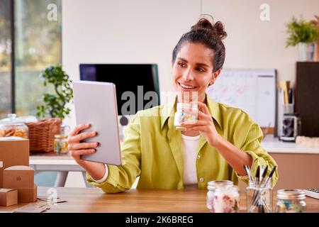 Frau, Die Online-Geschäfte Betreibt, Macht Zu Hause Boutique-Kerzen Mit Videoanruf Auf Einem Digitalen Tablet Stockfoto