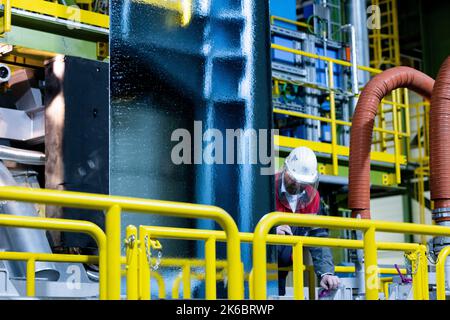 Dortmund, Deutschland. 13. Oktober 2022. Ein Mitarbeiter schaut sich eine neue Heißlackierlinie (FBA 10) auf dem Standort thyssenkrupp-Westfalenhütte an. Diese Investition stärkt die Position des Unternehmens als Deutschlands führender Flachstahlproduzent. Quelle: Rolf Vennenbernd/dpa/Alamy Live News Stockfoto