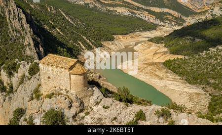 Eremitage von La Pertusa vor dem Montsec und der Mont-rebei-Schlucht mit dem fast trockenen Canelles-Stausee. La Noguera, Lleida, Katalonien, Spanien Stockfoto