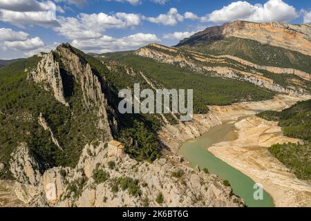 Eremitage von La Pertusa vor dem Montsec und der Mont-rebei-Schlucht mit dem fast trockenen Canelles-Stausee. La Noguera, Lleida, Katalonien, Spanien Stockfoto