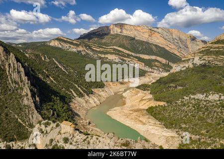 Eremitage von La Pertusa vor dem Montsec und der Mont-rebei-Schlucht mit dem fast trockenen Canelles-Stausee. La Noguera, Lleida, Katalonien, Spanien Stockfoto