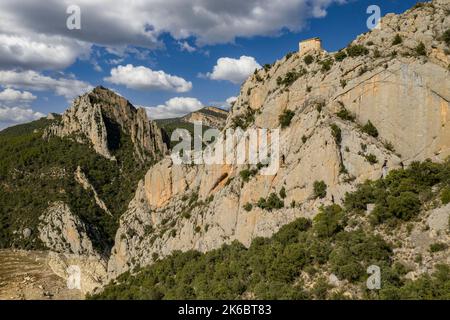 Eremitage von La Pertusa vor dem Montsec und der Mont-rebei-Schlucht mit dem fast trockenen Canelles-Stausee. La Noguera, Lleida, Katalonien, Spanien Stockfoto