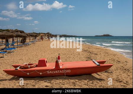 Portopalo, Italien - 09-17-2022: Schöner Strand mit Sand, türkisfarbenem und grünem Wasser ist ein roter Patino im Vordergrund in Portopalo di Capo Passero Stockfoto