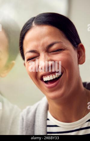 Kopf Und Schultern Porträt Einer Frau Oder Geschäftsfrau, Die Am Fenster Im Büro Oder Zu Hause Lachend Steht Stockfoto