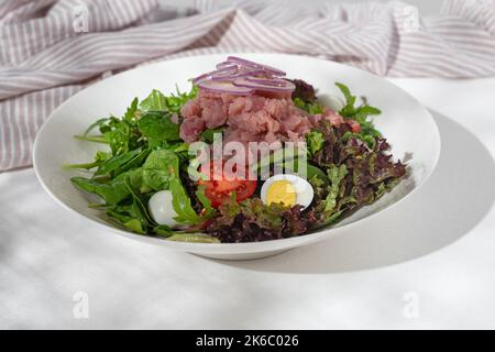 Traditionelles französisches Gericht, Nicoise-Salat mit Thunfisch auf weißem Hintergrund für die Speisekarte des Restaurants. Stockfoto