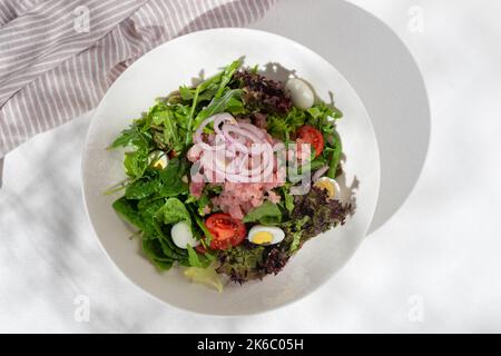 Traditionelles französisches Gericht, Nicoise-Salat mit Thunfisch auf weißem Hintergrund für die Speisekarte des Restaurants. Flach liegend Stockfoto