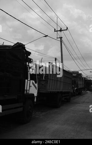 Materialtransporter, mehrere LKWs werden am Straßenrand im Cikancung-Gebiet - Indonesien geparkt Stockfoto