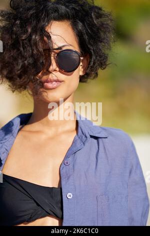 Der Sommer sieht gut aus. Eine junge Frau genießt die Sonne am Strand. Stockfoto