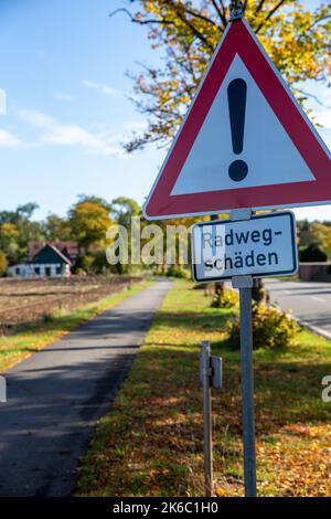 Verkehrszeichen, Verkehrszeichen 101 auf Einem Radweg mit der Aufschrift : Radwegschäden. Radweg parallel zu Einer Straße Stockfoto