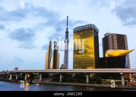 Blick auf das Bürogebäude der Asahi Group, den Metropolitan Expressway, den Sumida River und den Azumabashi Pier bei Sonnenuntergang von der Azuma Bridge. Stockfoto