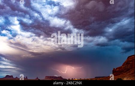 Ein Gewitter im bunten, bewölkten Nachthimmel über dem Monument Valley Navajo Tribal Park, Arizona Stockfoto