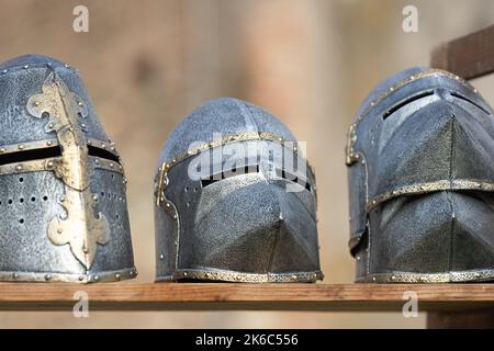 Drei mittelalterliche Helme über einem Holzbrett Stockfoto