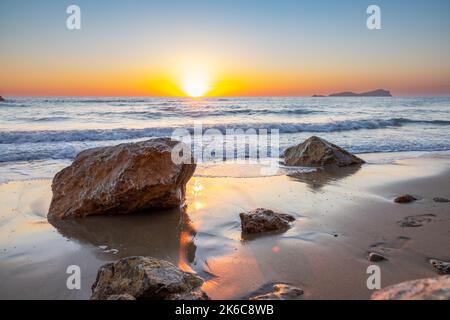 Das Bild vom 2022. September zeigt die Wellen am Strand Aqua Blancas auf Ibiza bei Sonnenaufgang, während sie sich am Ufer abwaschen. Stockfoto