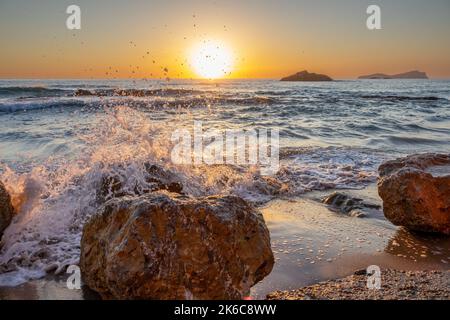 Das Bild vom 2022. September zeigt die Wellen am Strand Aqua Blancas auf Ibiza bei Sonnenaufgang, während sie sich am Ufer abwaschen. Stockfoto