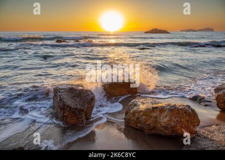 Das Bild vom 2022. September zeigt die Wellen am Strand Aqua Blancas auf Ibiza bei Sonnenaufgang, während sie sich am Ufer abwaschen. Stockfoto