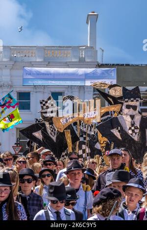 Menschen, die große Figuren aus Papier und Withy Boys in der Parade bei den Feierlichkeiten zum Mazey Day im Rahmen des Golowan Festivals in Penz tragen Stockfoto