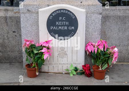 Westminster, London, Großbritannien. 12.. Oktober 2022. Pflanzen und stieg am Denkmal für PC Keith Palmer vor dem Unterhaus zurück, der am 22.. März 2017 im Dienst als Polizist im New Palace Yard ermordet wurde. Quelle: Maureen McLean/Alamy Stockfoto