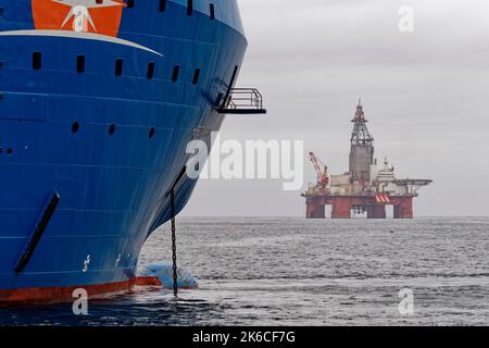 Die Bohranlage West Hercules liegt nahe der Küste und das Unterstützungsschiff Horizon Arctic ist am Dock vertäut. Stockfoto