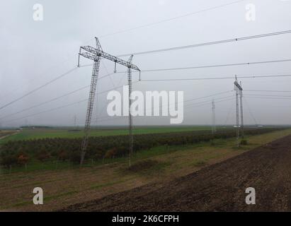 Stromleitungen, die sich über die Landschaft ausbreiten. Energiekrisenkonzept Stockfoto