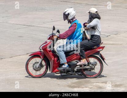 SAMUT PRAKAN, THAILAND, Okt 04 2022, Ein Taxifahrer auf einem Motorrad fährt mit einer Frau. Stockfoto