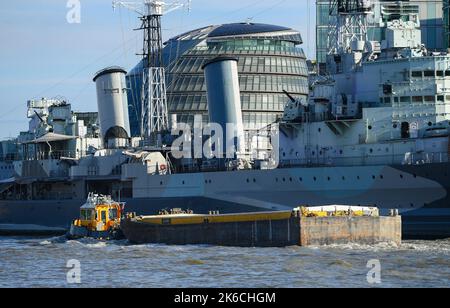 SWS Essex passiert die HMS Belfast und zieht einen Lastkahn die Themse hinauf zur London Bridge. VEREINIGTES KÖNIGREICH Stockfoto