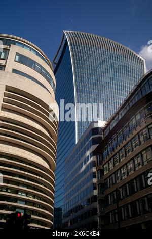 Ein Blick auf die 20 Fenchurch Street durch die hohen Gebäude des Londoner Finanzviertels, der bei sonnigem Wetter gefangen ist. Stockfoto