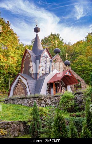 Das Gebäude der orthodoxen Kirche vor dem Hintergrund des Herbstwaldes. Stockfoto