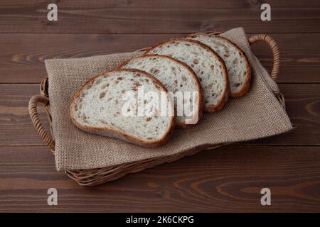 Geschnittenes Roggenbrot isoliert auf einem Holztisch Stockfoto