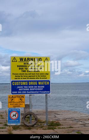 Warnschilder über plötzliche große Wellen, Gepflochs-Beobachtung, Risiko von Ausrutschen und Stürzen und Hundefouling im Bulloch Harbour Dalkey in der Nähe von Dublin Ireland Stockfoto