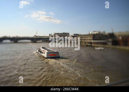 City Cruises Boot, das in Richtung Blackfriars Bridge London UK fährt, aufgenommen mit Shift-Objektiv-Effekt im Abendlicht. Stockfoto