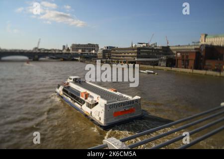 City Cruises Boot, das in Richtung Blackfriars Bridge London UK fährt, aufgenommen mit Shift-Objektiv-Effekt im Abendlicht. Stockfoto