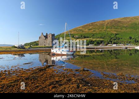 Lochranza Castle und Segelboot im seichten Wasser reflektiert, Lochranza Bay, Arran, Isle of Arran, Bute, Buteshire, Schottland, Vereinigtes Königreich Stockfoto
