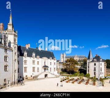 Gesamtansicht des Château des Ducs de Bretagne (Schloss der Herzöge der Bretagne) in Nantes, Frankreich, mit der Kathedrale in der Ferne. Stockfoto